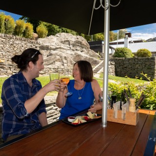 Historic stone wall behind diners on Buckingham Green, Arrowtown